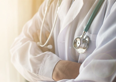 A doctor folding his arms together.