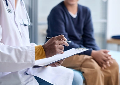 A medical doctor speaking with and evaluating a patient.