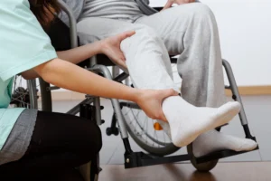 Doctor evaluating knee pain of person in wheelchair