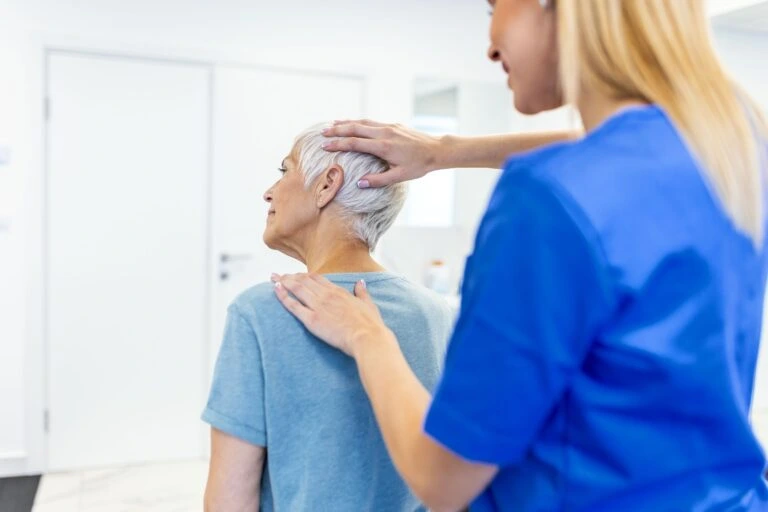 A neck pain doctor evaluating a patient.