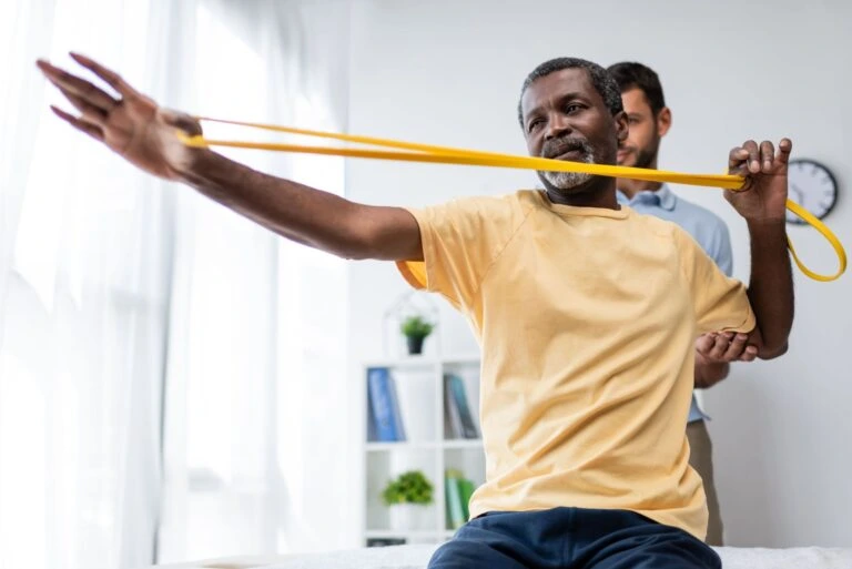 An elderly man doing physical therapy exercises.
