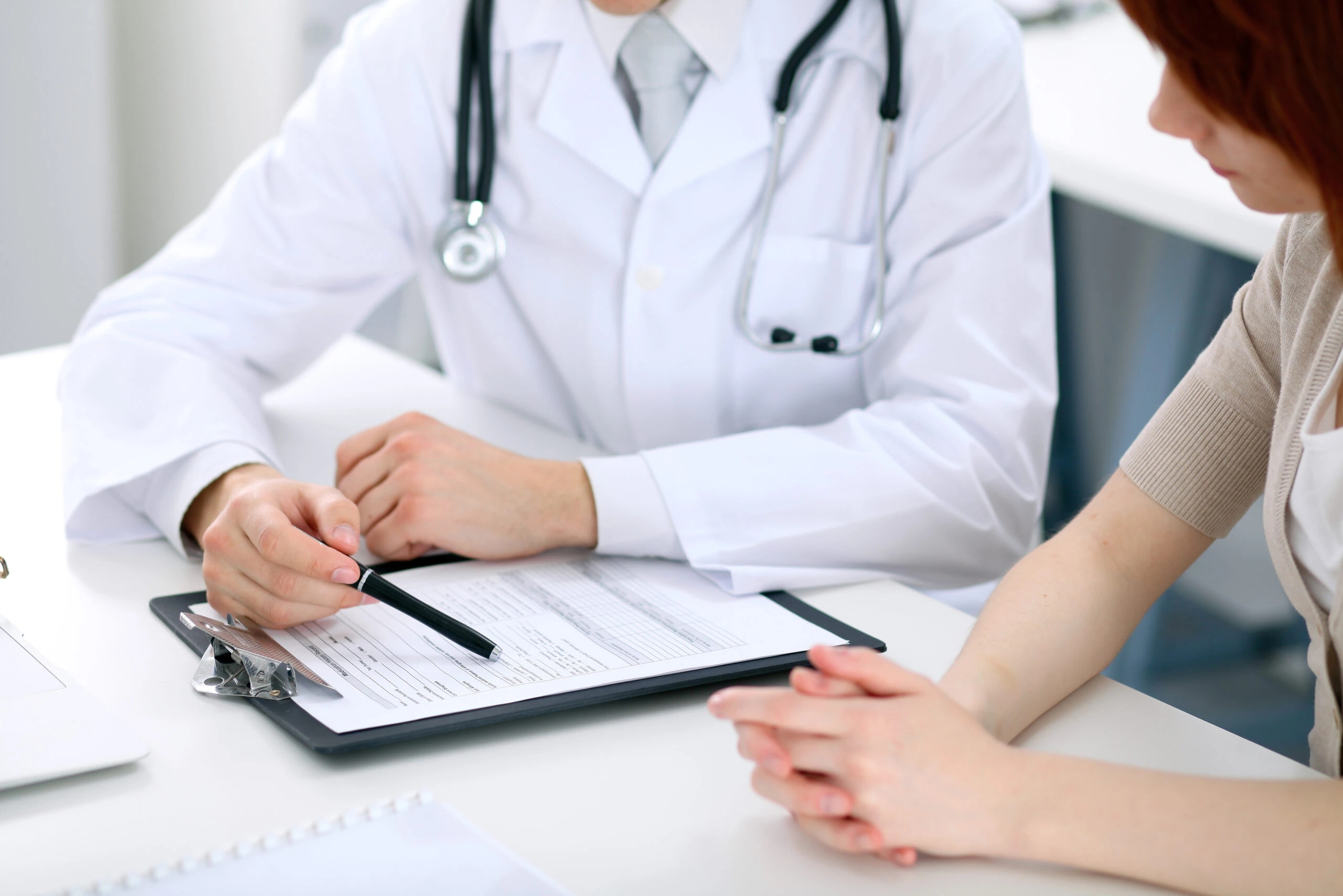 A board-certified medical doctor reviewing initial assessment results with a patient.