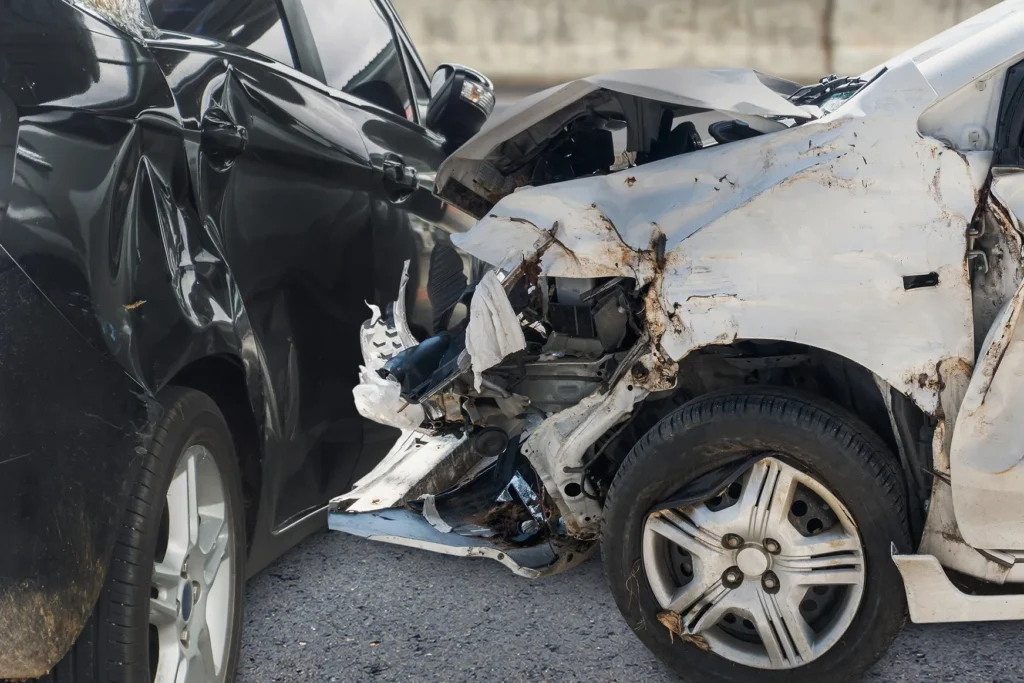 Two severely damaged cars after a crash, showing why it's important to know when to talk to a lawyer after a car accident.