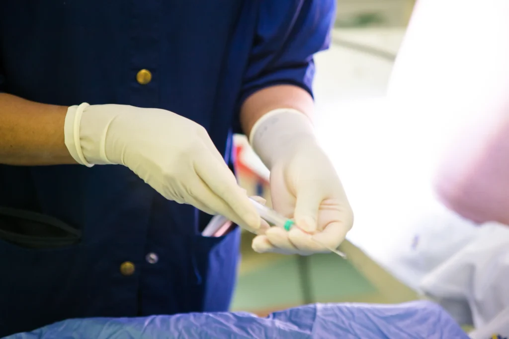Medical professional wearing gloves preparing a syringe for use, representing various injection therapies.